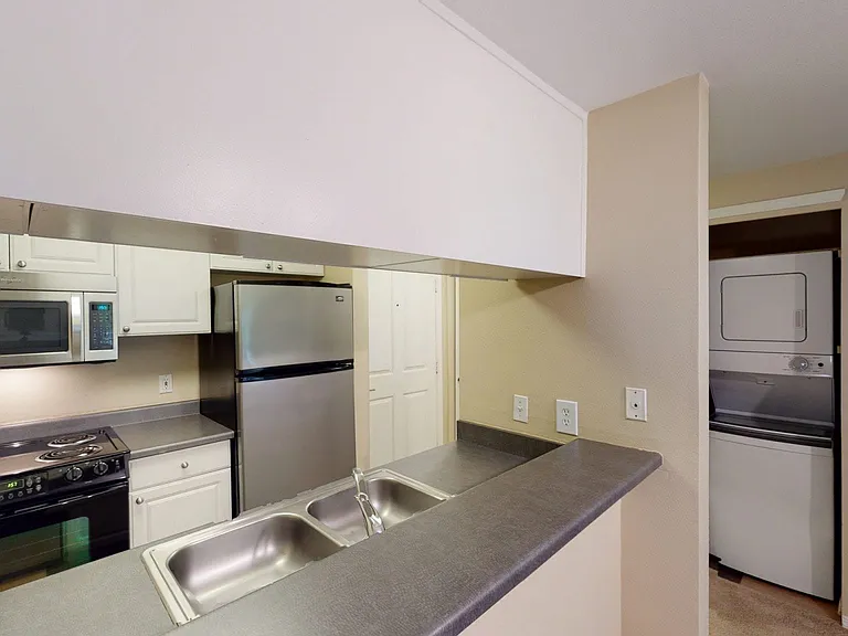 Apartment kitchen with wood-style flooring.