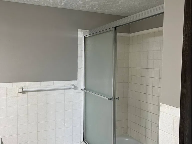 Large bathrub with glass sliding door in a unit at Whispering Isle.