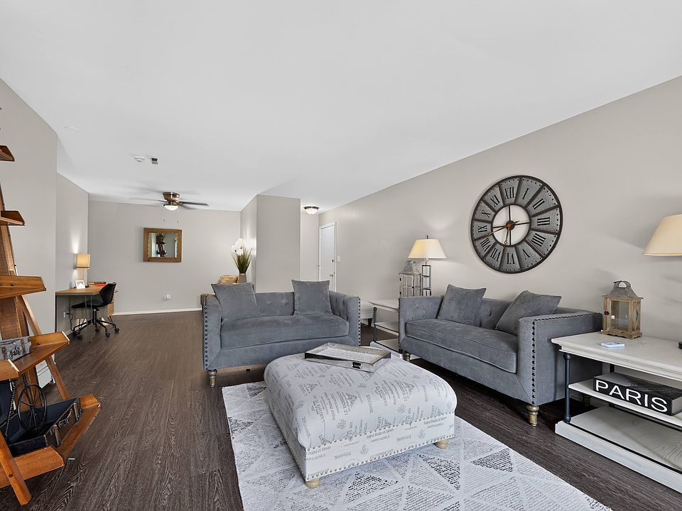 Settle into a stylish living room featuring a grey couch and a charming layout at Renaissance at Carol Stream in Carol Stream, IL.