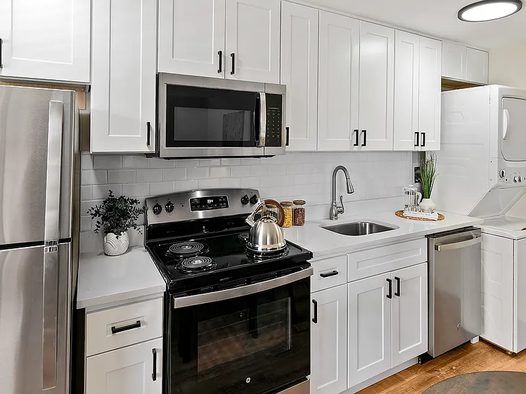 Gorgeous new kitchen with white Shaker cabinets and stainless-steel appliances, including a microwave and dishwasher. In-unit washer and dryer.