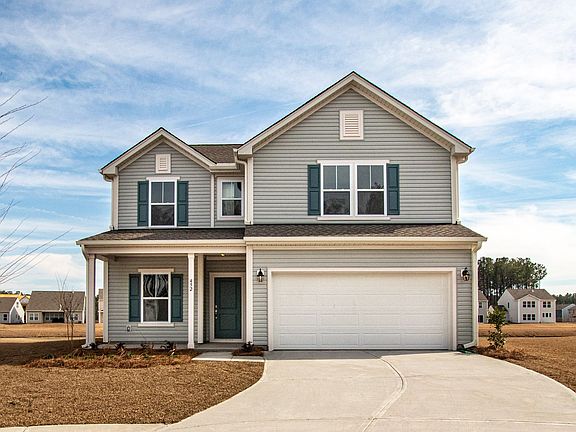 A large house with a white garage door and blue shutters