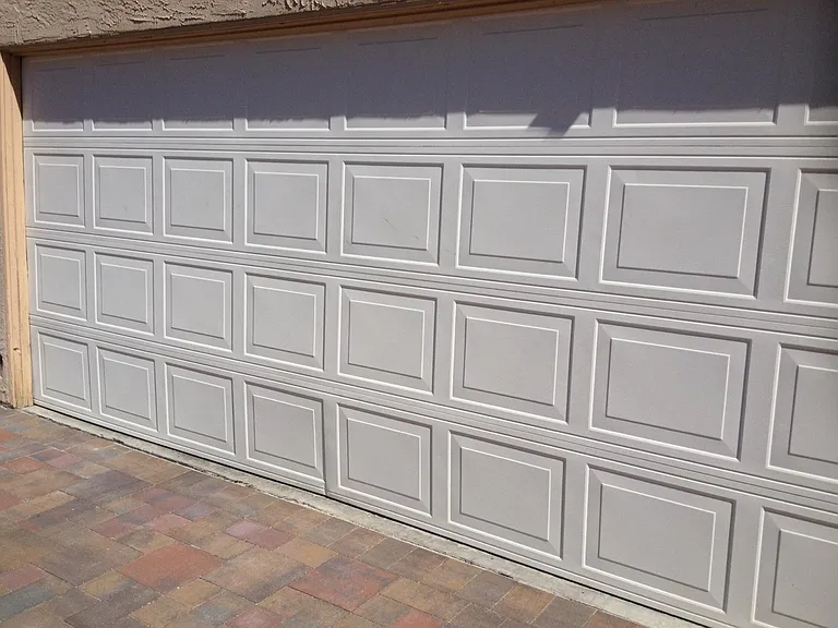 Back grage door, with pavers throughout.