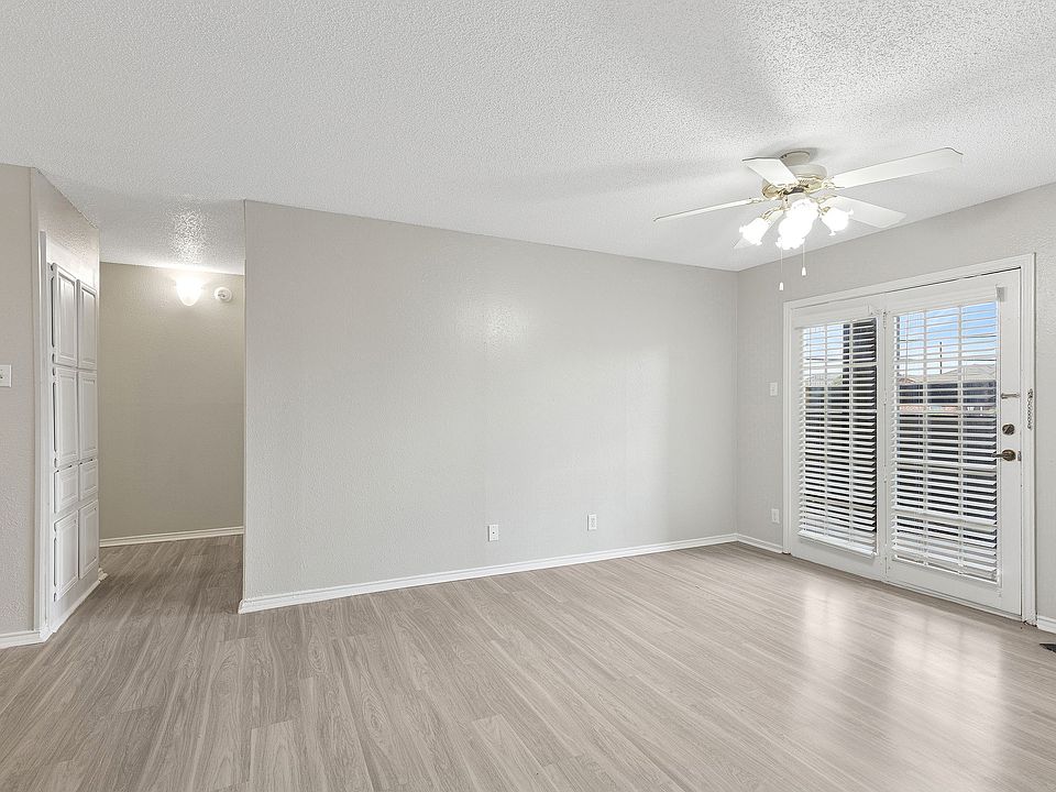 A bright living room is shown with vinyl floors and doors opening to private patio.