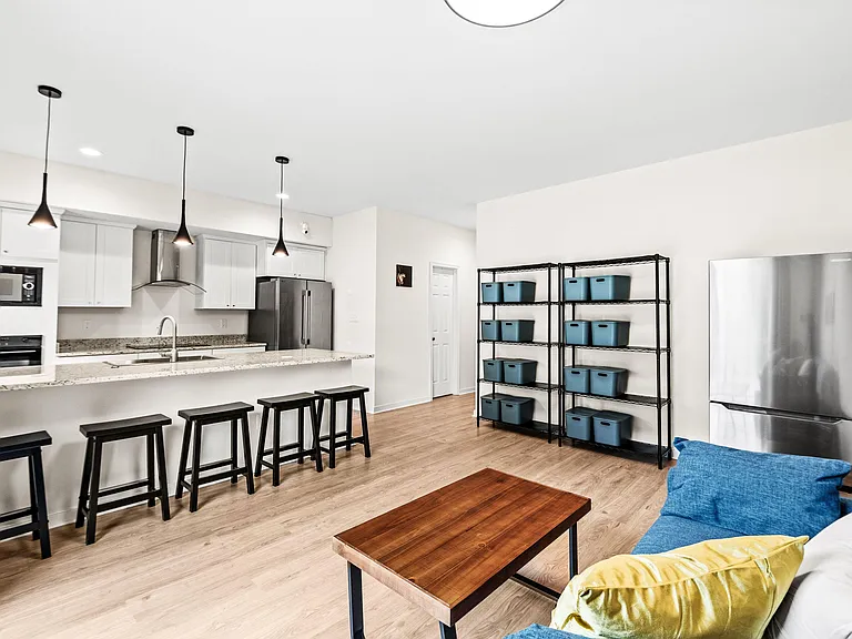Open-concept kitchen with breakfast bar seating, stainless appliances, pendant lighting, and ample counter space.