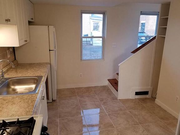 Kitchen with stairs to second floor bedrooms & balcony