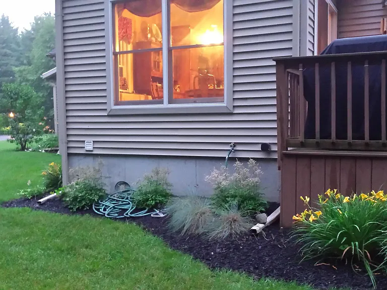 Backyard partial view of home and deck.
