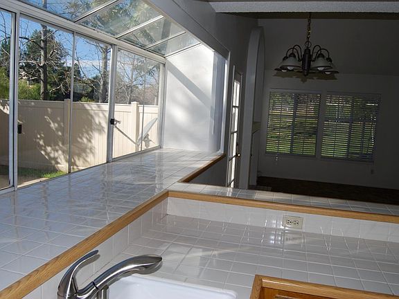 looking from kitchen to living room. door to patio on the left. just beyond that door-on the left-is a fireplace. windows on left look out to small yard, while other windows with blinds look out to grass common area