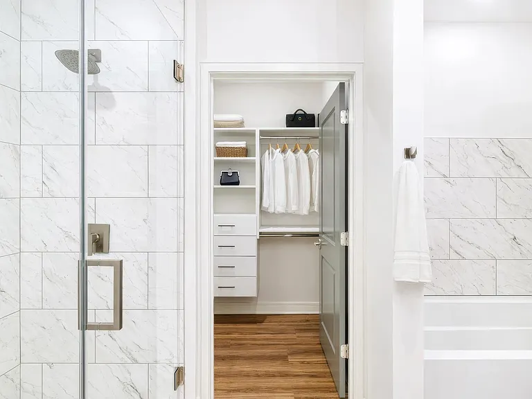 A penthouse bath that flows directly into a custom closet, designed for easy mornings and streamlined storage.