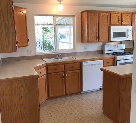 The window above the sink provides a view of the neighborhood and some nice foliage too...