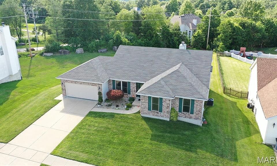 Charming brick-front atrium ranch home with inviting curb appeal, featuring a spacious front lawn, and an attached two-car garage. Nestled in a quiet, well-maintained neighborhood.