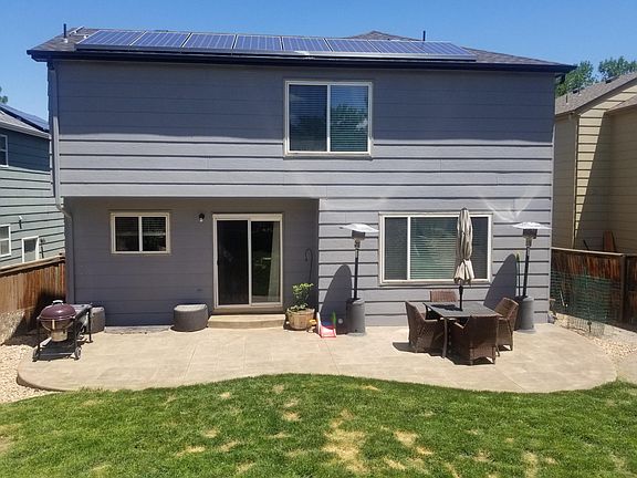 Back of home with stamped concrete patio