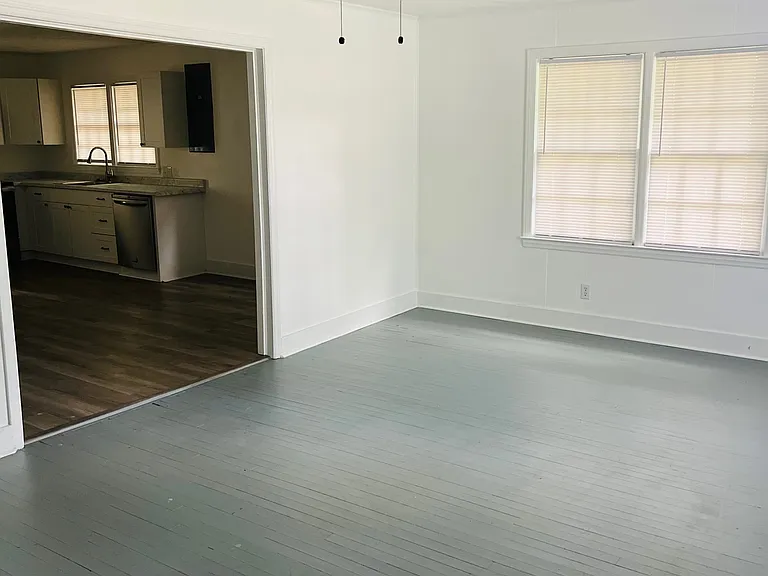 Large living area with new blinds and ceiling fan.