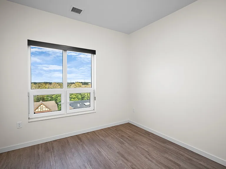 Bright, airy room featuring large window with scenic view, light wooden flooring, and freshly painted walls. Bright, airy room featuring large window with scenic view, light wooden flooring, and freshly painted walls.