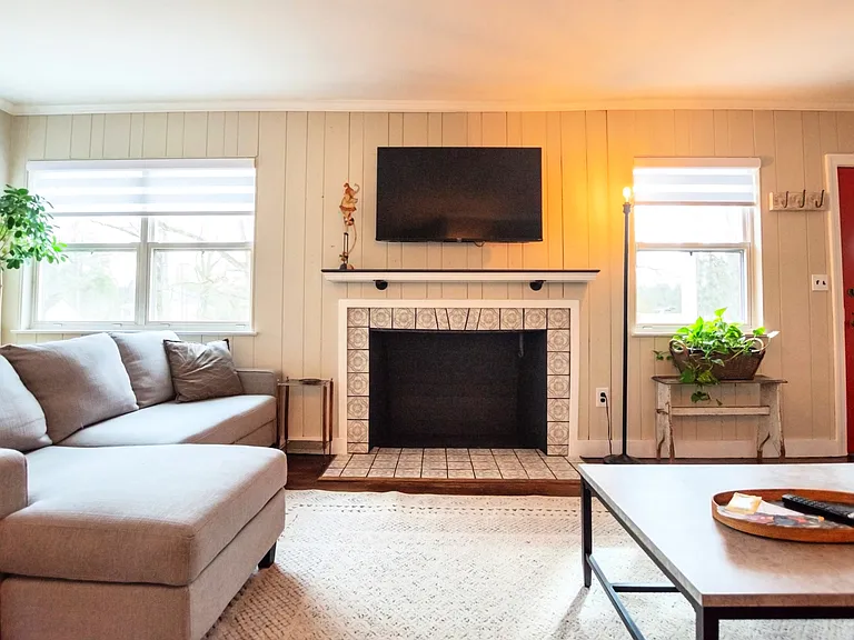 Expansive living room with decorative fireplace and multiple seating areas for watching tv or relaxing