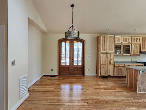 The foyer leads into an open dining room. The doors open onto an enclosed cedar screened porch.