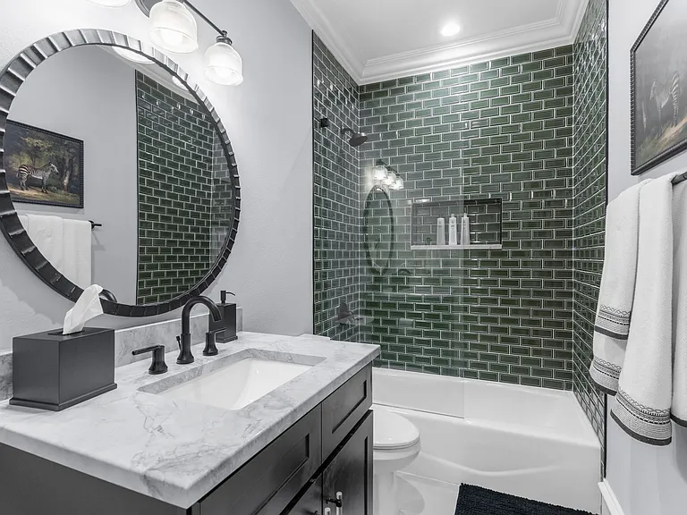 Striking first-floor full bathroom with designer emerald green tile and modern finishes.