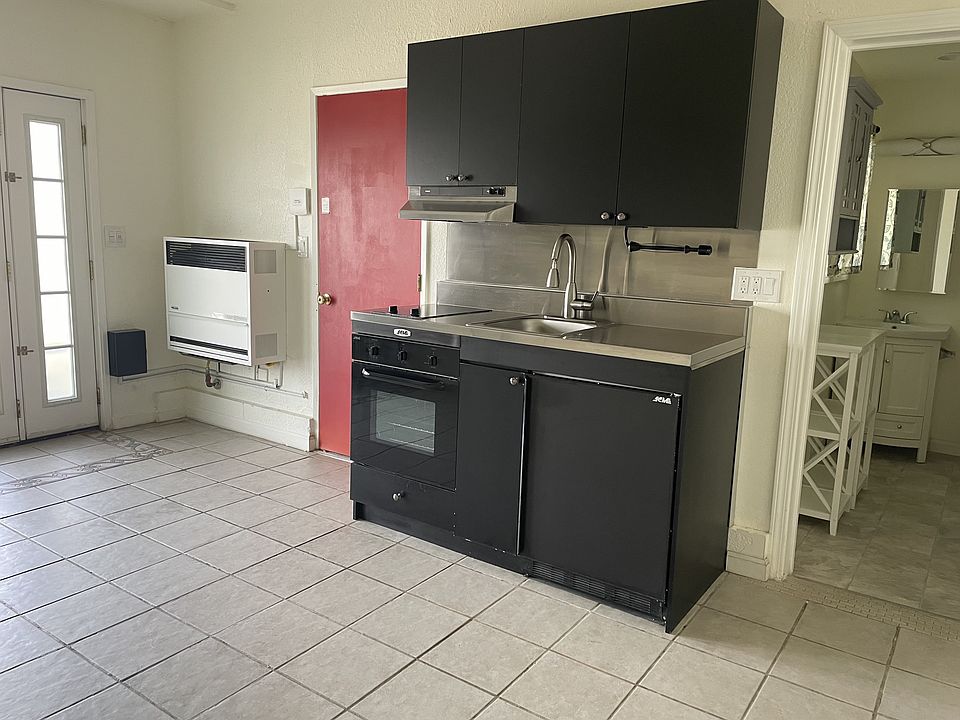 From the left: front door, wall heater (no AC - not needed - SJB has a mild climate); side door; kitchen (new microwave not shown) w/ stove, oven, frig, sink/awesome faucet, garbage disposal; bathroom