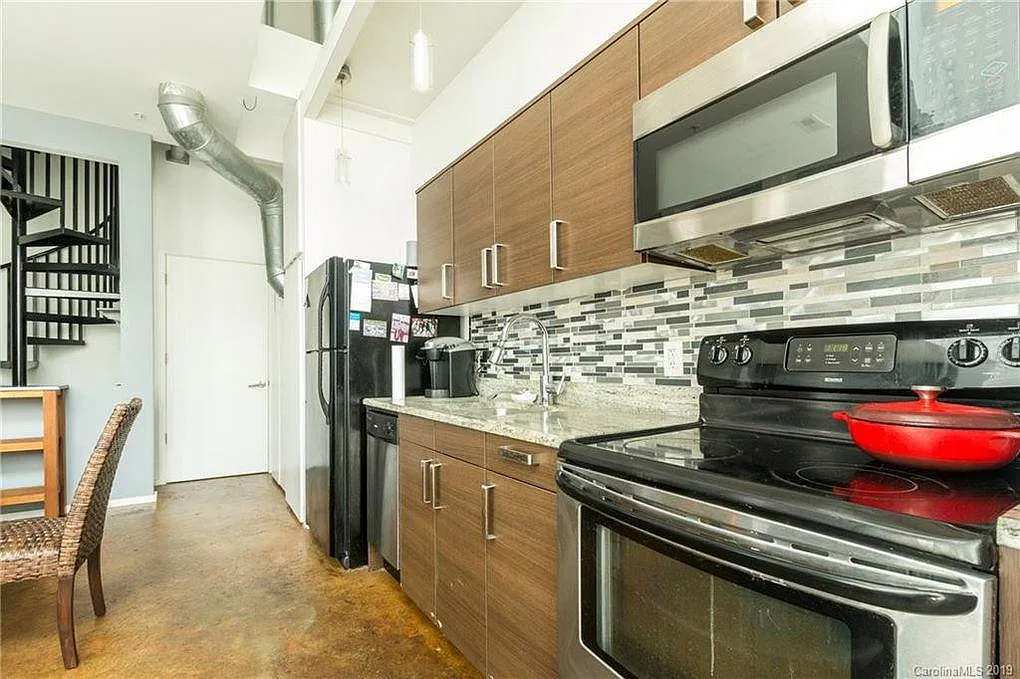 Kitchen includes stainless steel appliances with modern tile backsplash.