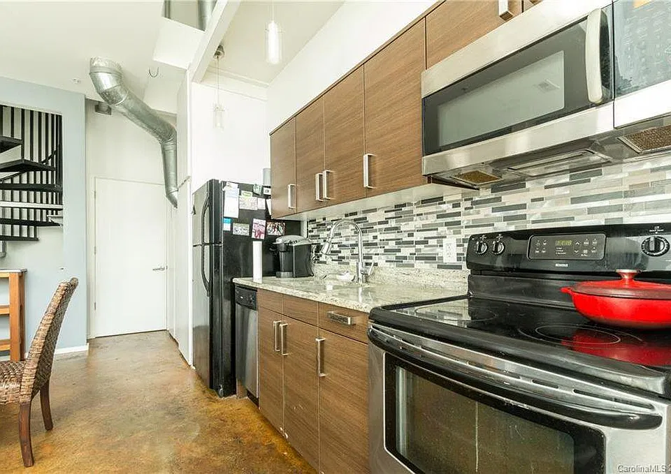 Kitchen includes stainless steel appliances with modern tile backsplash.