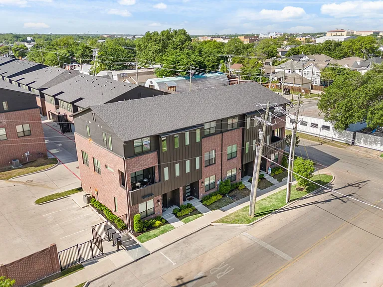 Exterior, aerial view of front of the townhome with street parking in front for tenants or guests. Additional tenant parking in the gated area is on the right.