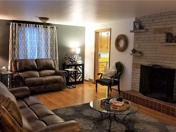 Large Family room has hardwood floors and a raised stone wood burning fireplace