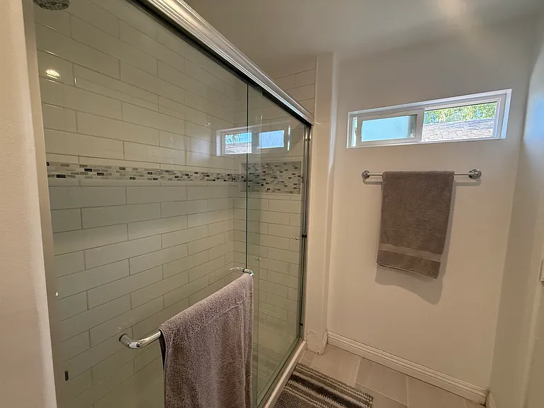 Sleek glass-enclosed shower with contemporary tile accents