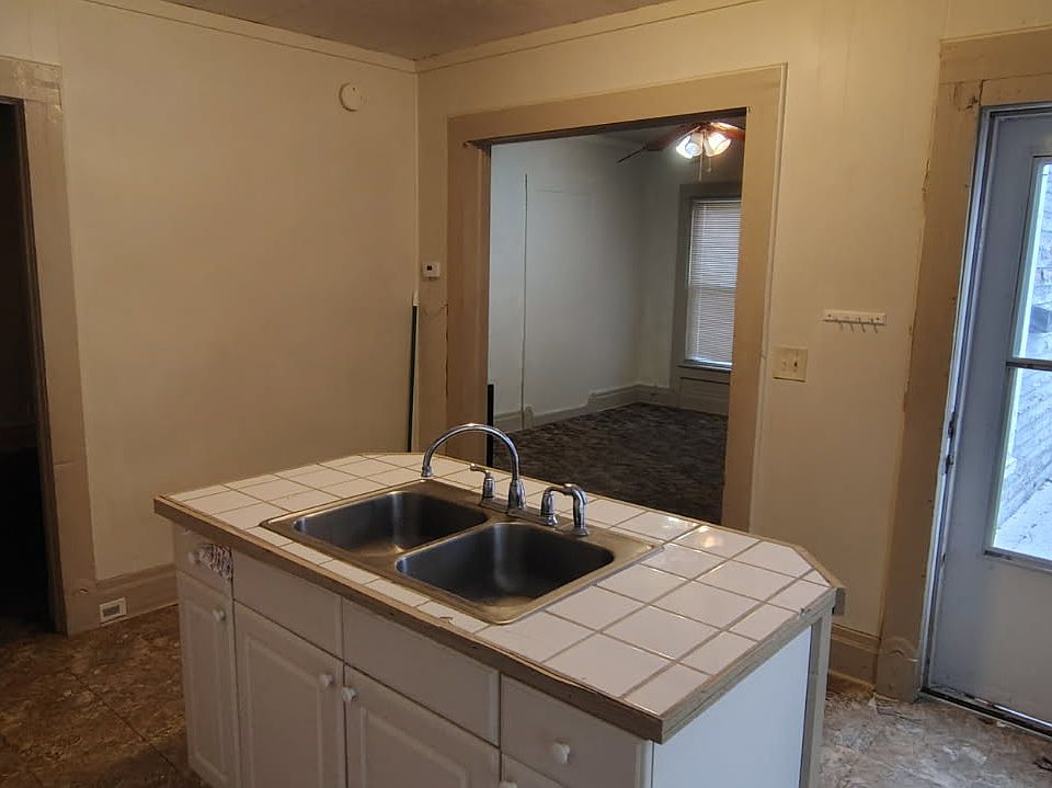 View to the front door and living room with bedroom door to the left