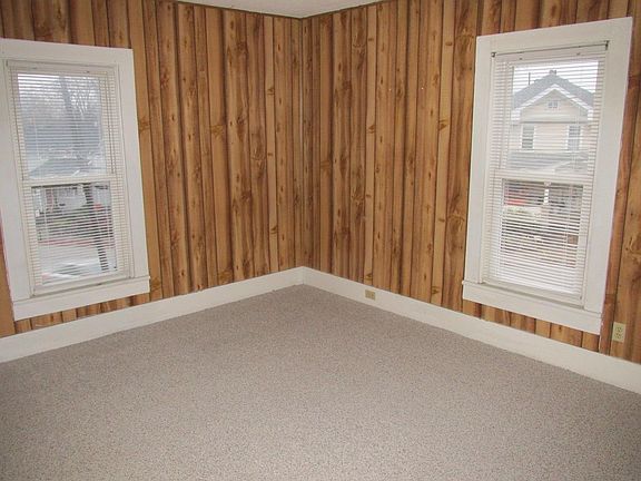 Living room - new carpet installed. Insulated windows. Nice paneling. Double hung insulated windows.