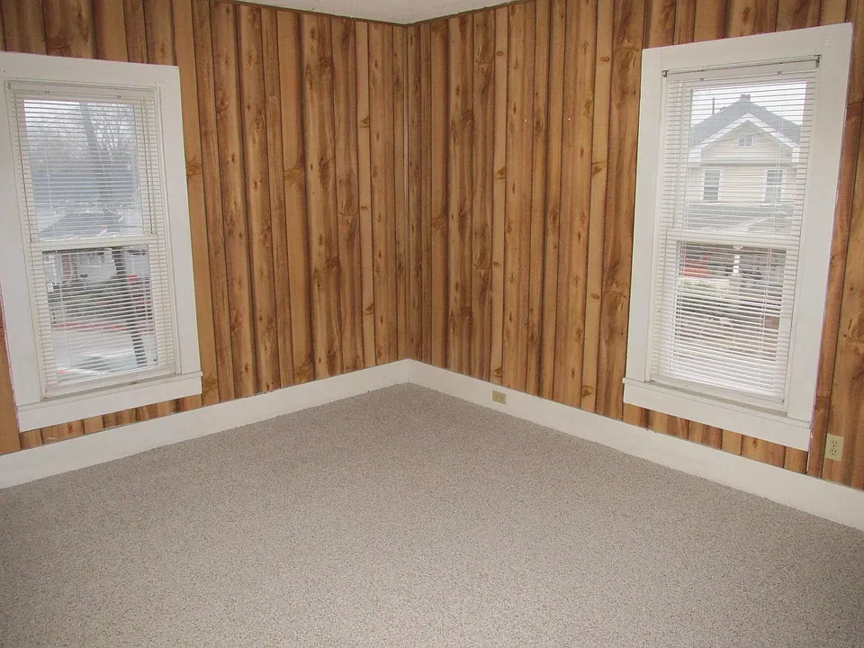 Living room - new carpet installed. Insulated windows. Nice paneling. Double hung insulated windows.