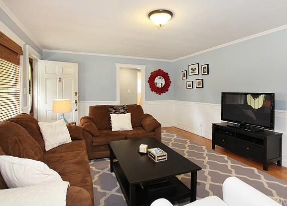 Beautifully Finished Living Room with Wainscoting, Crown Molding, Custom Window Coverings, Refinishe