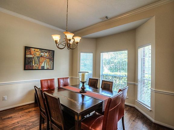 Gorgeous dining room features bay window, crown molding and warm, handscraped hardwood floors.