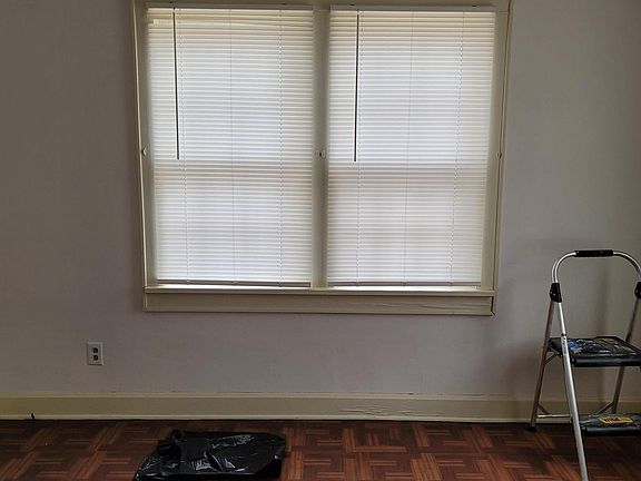 Dining room boasts a charming, low-maintenance parquet floor, ceiling fan and miniblinds.