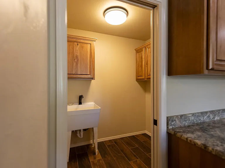 laundry room with maple cabinets and utility sink