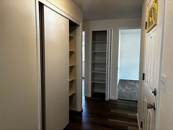 Entry closet with storage shelves and hallway linen closet