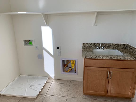 Laundry features cabinets & utility sink.