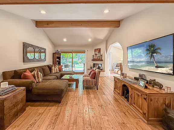 Living room/media room with large screen smart TV leading to outdoor living space