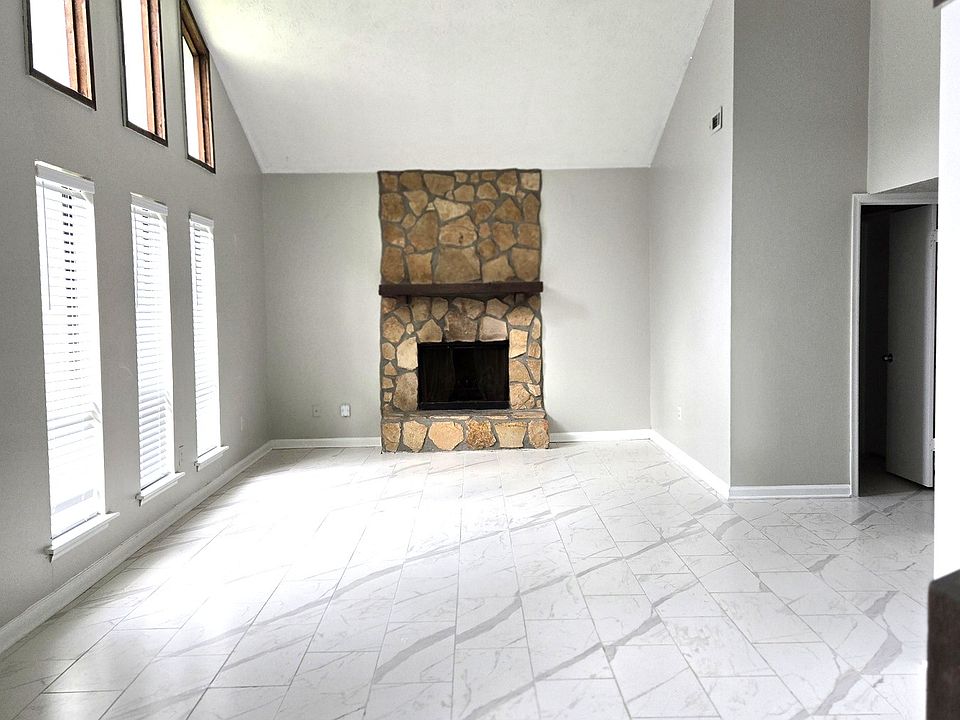 Spacious 2-story high living room with marble look floor
