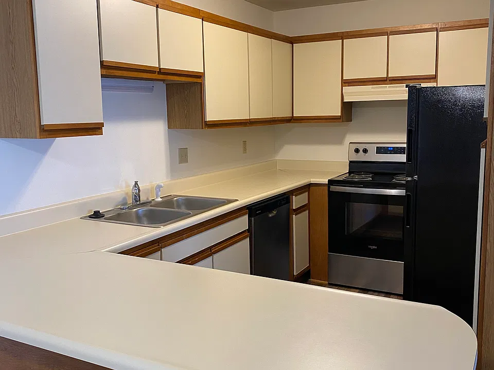 Kitchen with snack bar, dishwasher, stove & refrigerator.