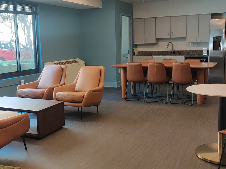 Community room, with full kitchen for hosting events and tables and chairs for lounging on the first floor.
