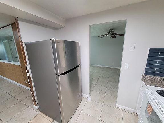 Modern kitchen featuring a brand-new stainless steel refrigerator with top freezer and bottom fridge, adding sleek style and convenient storage to this functional space.