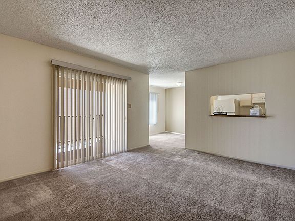 A large living room with sliding glass doors out to the patio and easy access to the kitchen