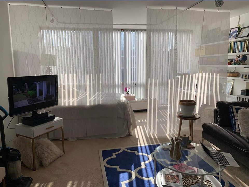 Living/bedroom area with floor to ceiling windows.