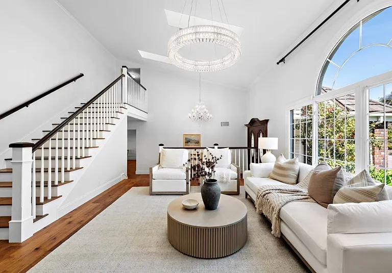 Alternate view of the bright, airy living room showcasing large windows and natural light.