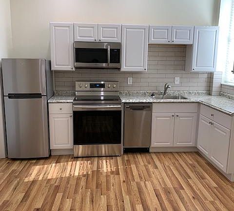Kitchen Area with Stainless Steel Appliances; Refrigerator, Range/Oven; Microwave, Dishwasher; Sink/Garbage Disposal; Porcelain Tile Back Splash; White Cabinets; LED Dimmer Controlled Ceiling Lighting; Laminated Hardwood Flooring