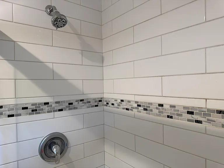 Custom tile shower with decorative accent tile.