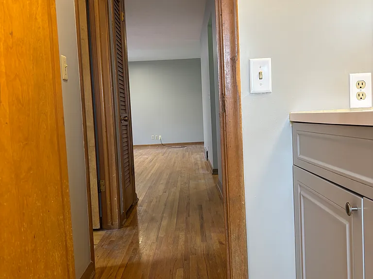 Bathroom looking out to hallway/living room (linen closet to left and hall closet to right)