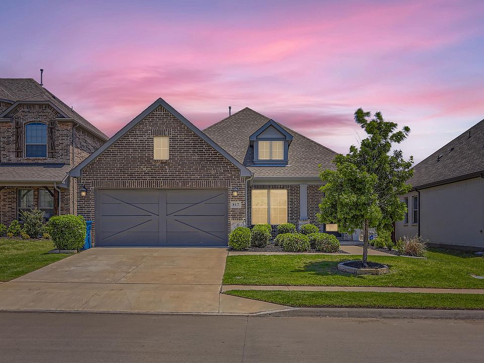 View of front of home with a garage and a yard