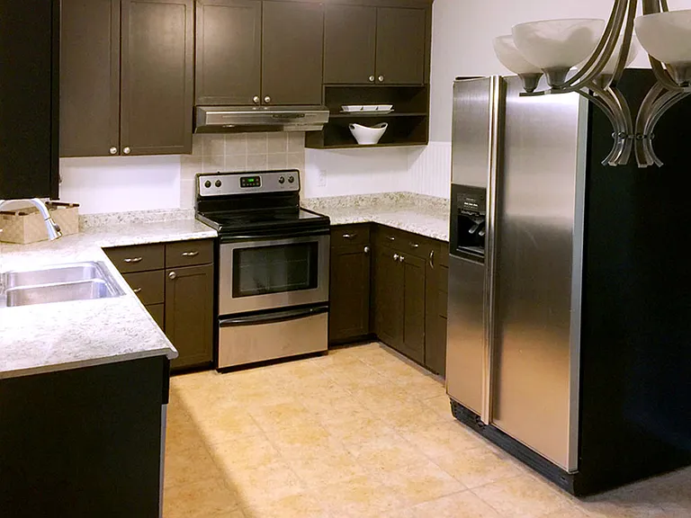 Eat-in kitchen with stainless steel appliances _ dishwasher, large refrigerator, range _ and plenty of counterspace and storage.