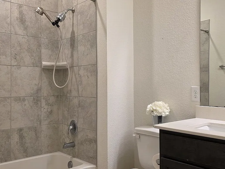 Second bathroom features a tub/shower combination with tile surround