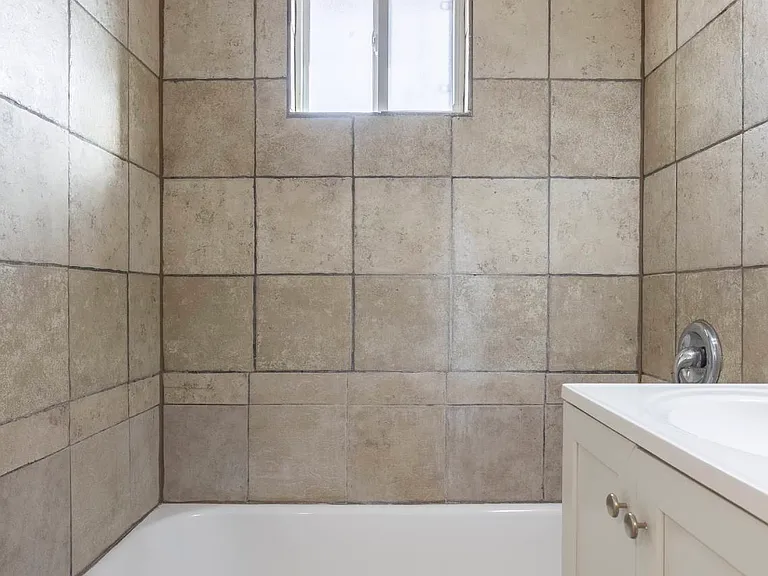 Bathroom with tan tiles.